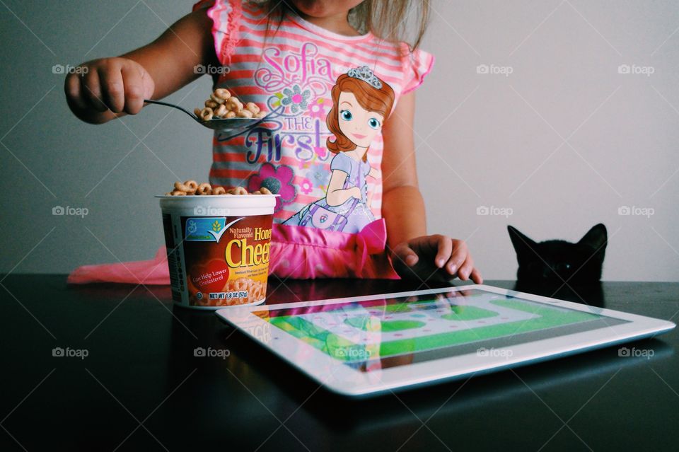 Girl holding spoon of oat cereal