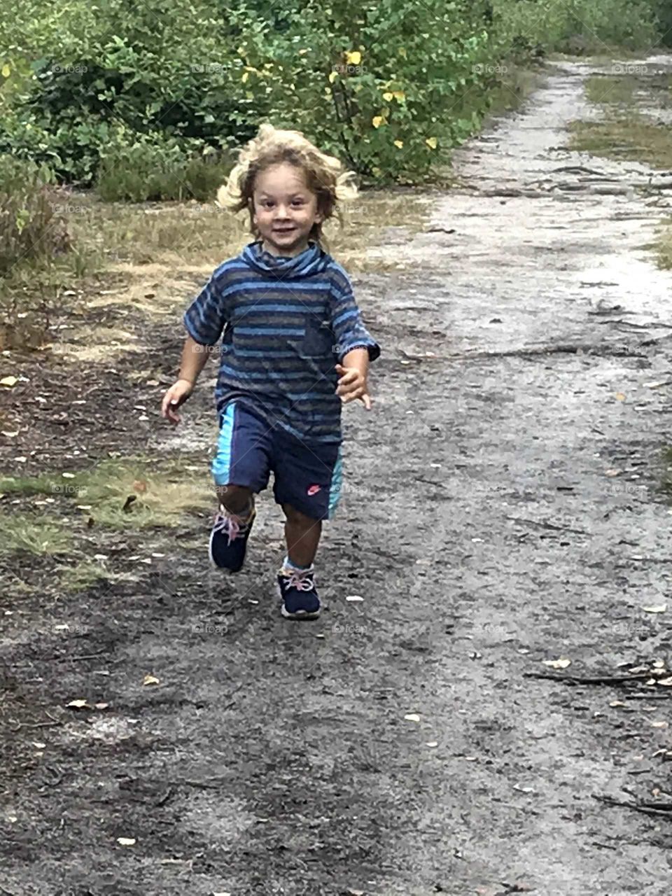 Little boy running in a forest