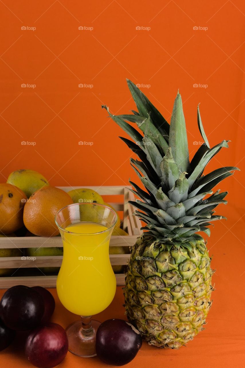 Oranges and Glass with natural juice on an orange background