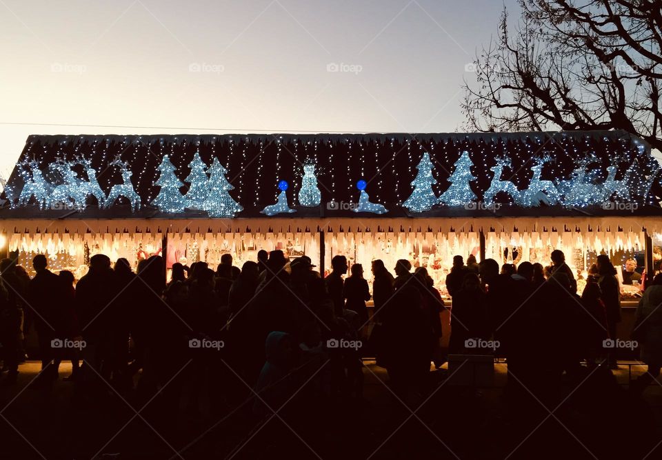 Night Christmas lights on market stands with unrecognizable people silhouettes in the front, Montreaux, Switzerland 