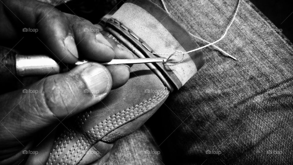 Costura artesanal manual, sapateiro. Mão coturno, suvela e linha.
