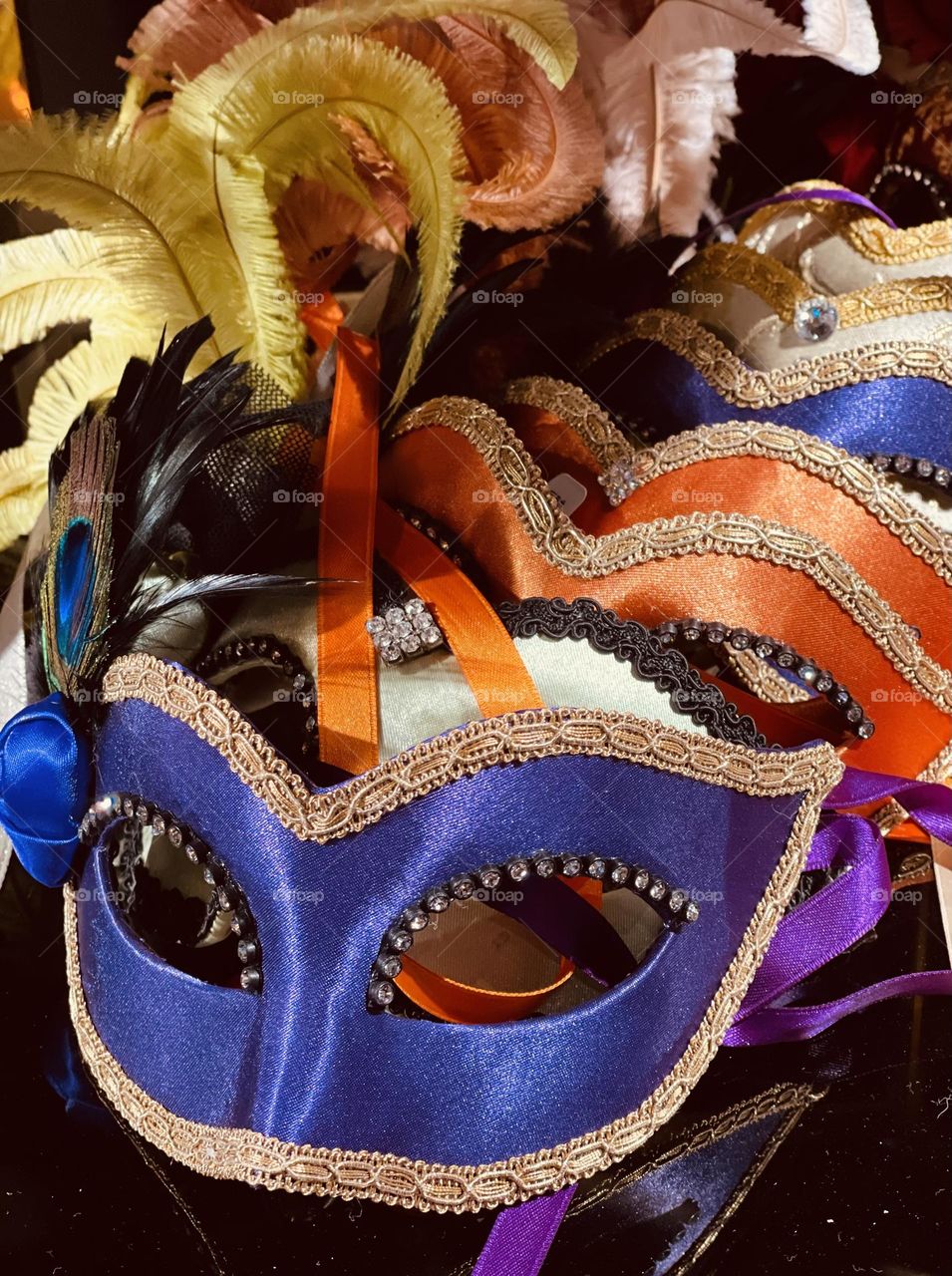 Carnival masks covered in colored satin and decorated with lace and feathers