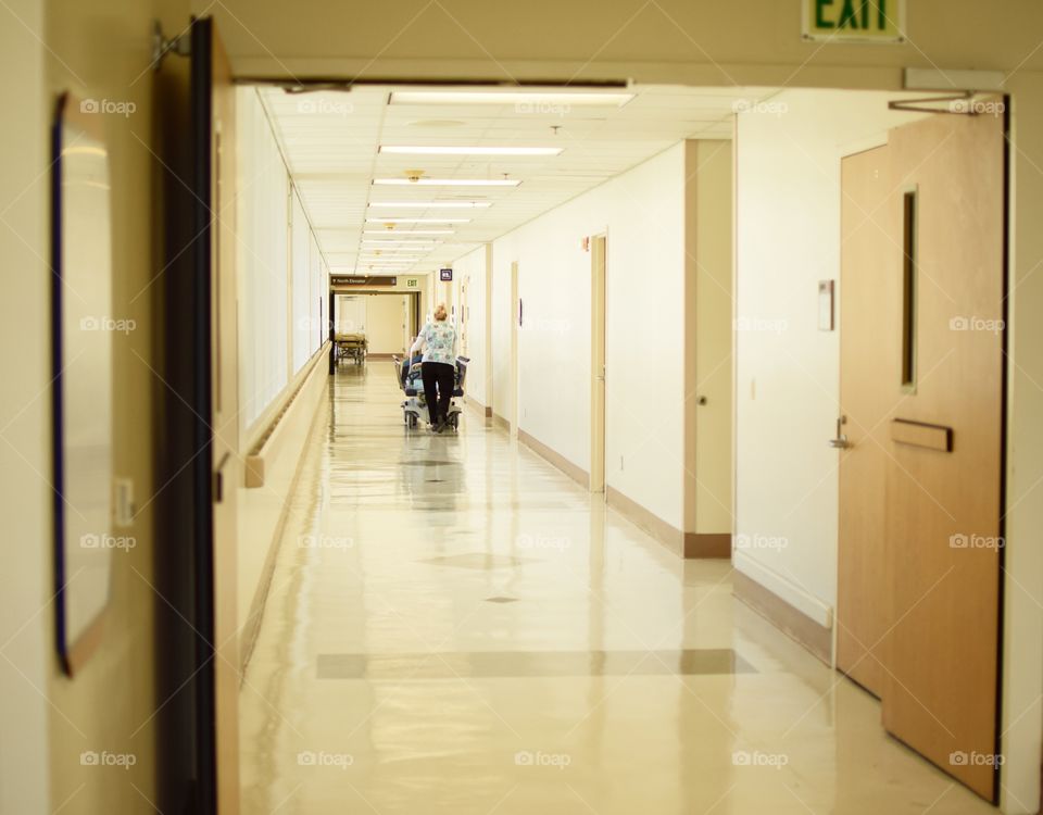 Person Pushing gurney down Hospital Hallway 