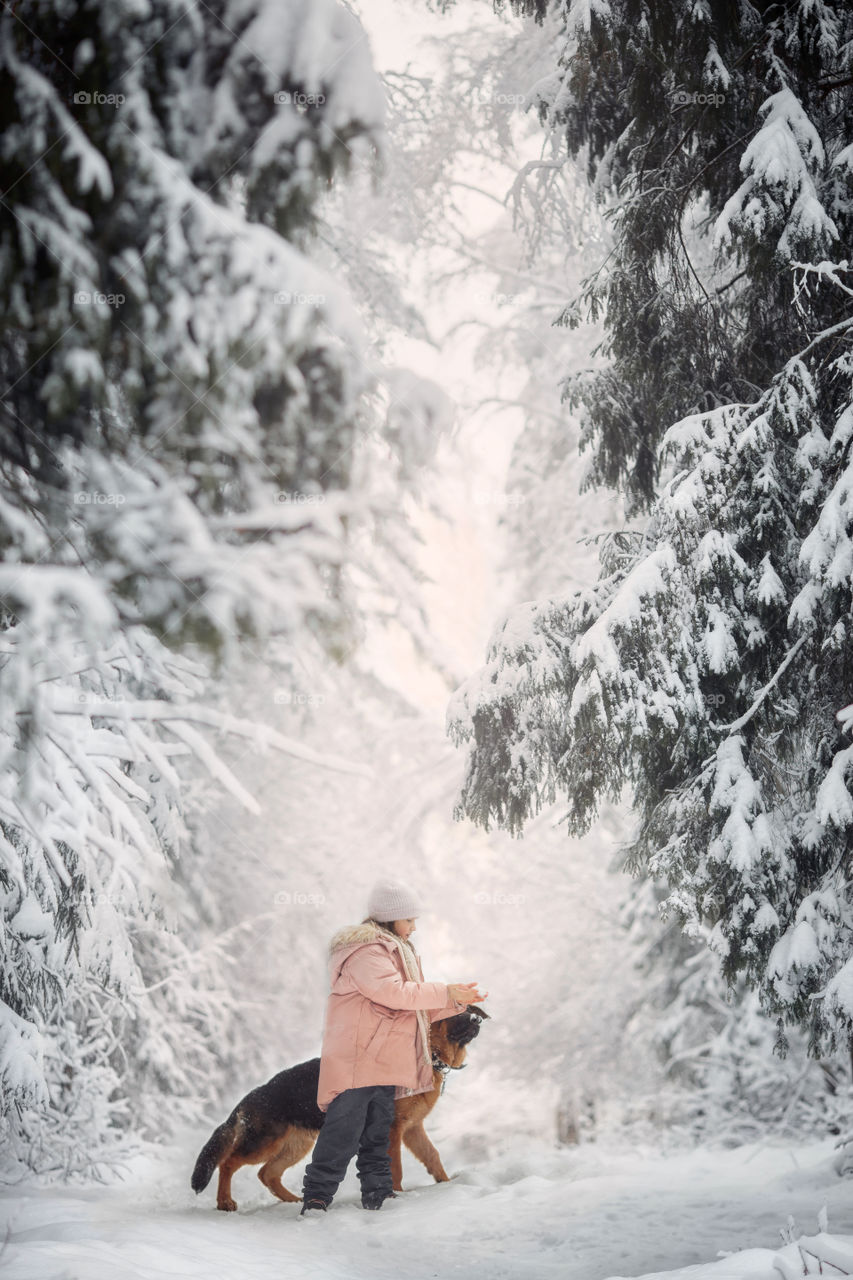 Portrait of beautiful Little girl and puppy at winter forest