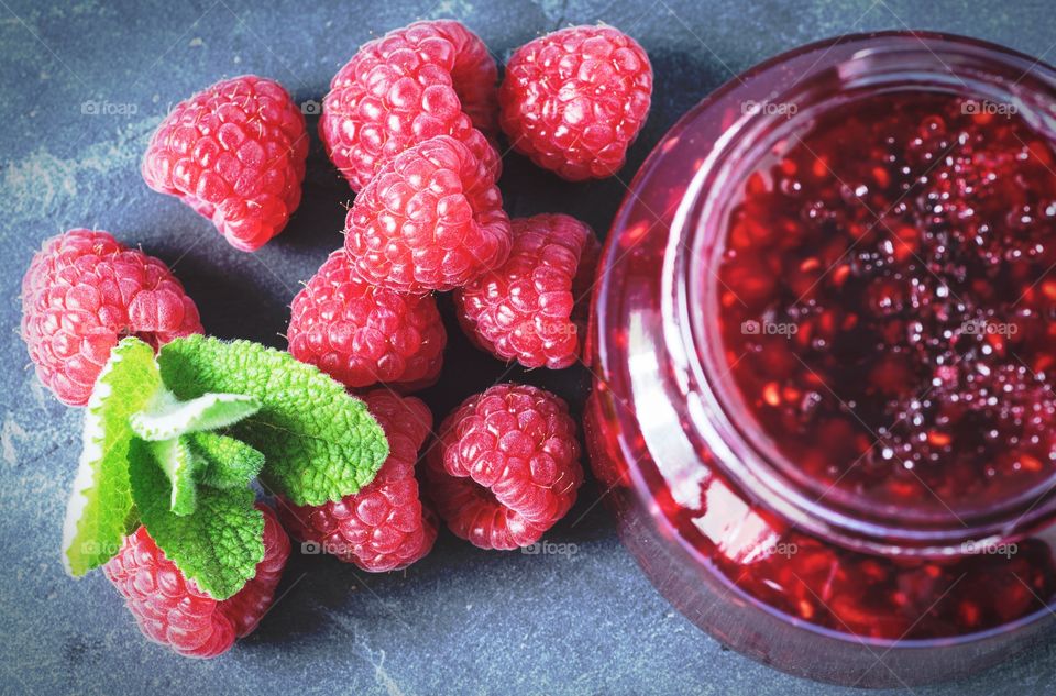 High angle view of raspberry jam with raspberries