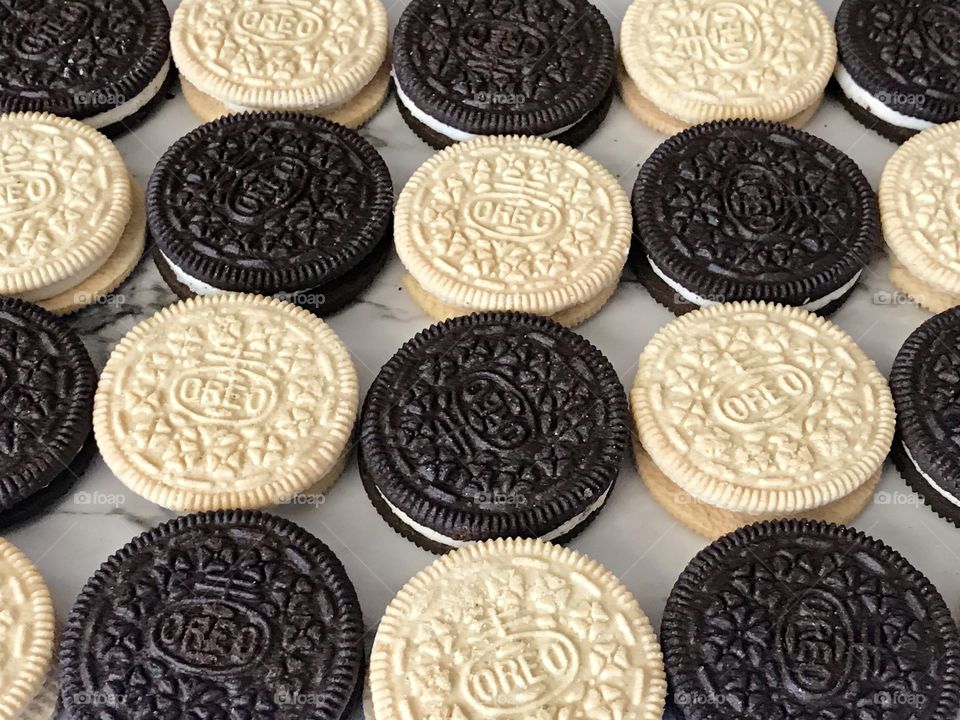 Golden and a chocolate double stuff Oreo cookies in a contrasting flat lay