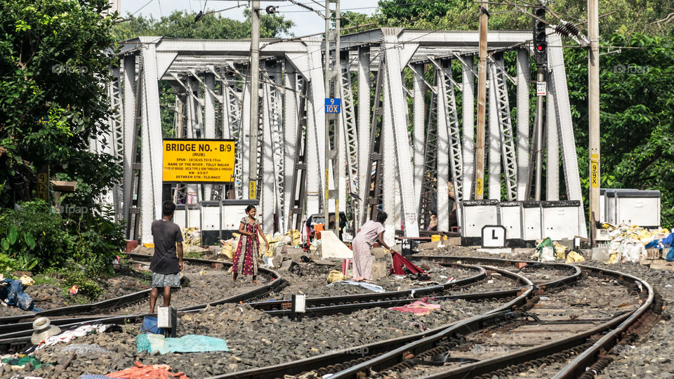 Kolkata, August 20, 2019 – A slum area on the Indian railway tracks near New Alipore Station, Kolkata, India. Newly construction Steel Bridge at a distance.