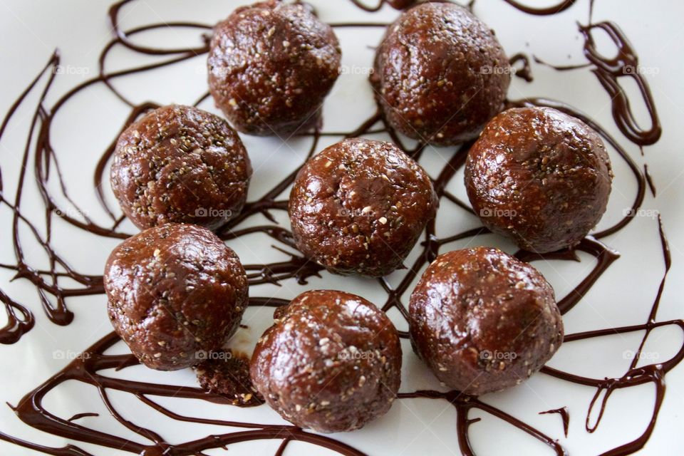 More Chocolate - Nut Butter Cocoa Bites on white plate with chocolate drizzle closeup