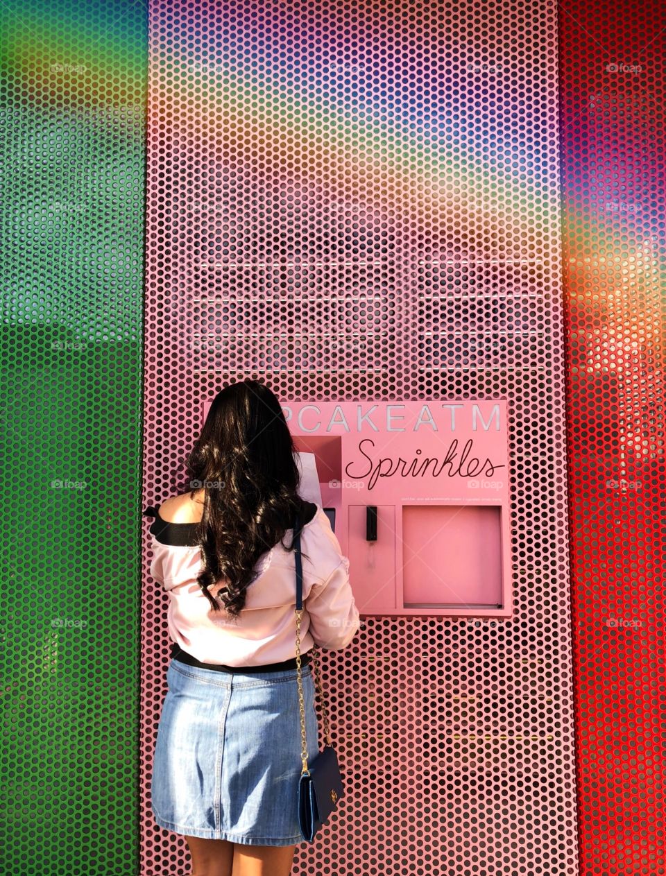 Girl withdrawing cupcakes from the Sprinkles cupcake atm