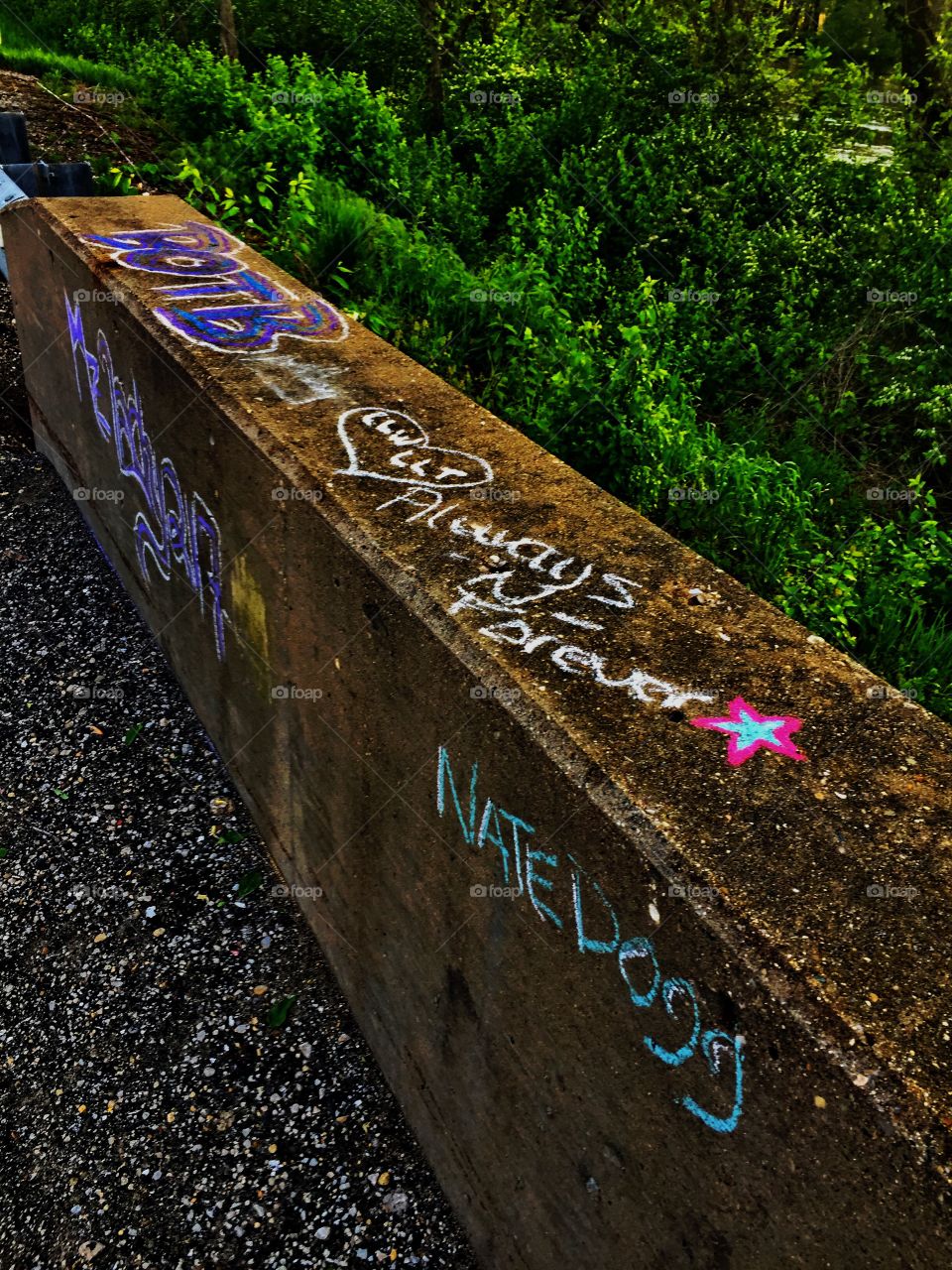 Some chalk graffiti art on the side of a county bridge 