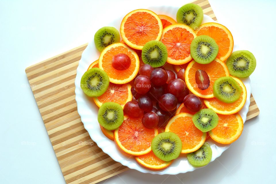 citrus and tropics fruits on a plate top view table background