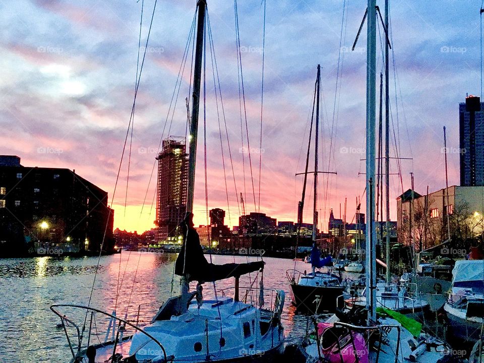 Boats up against the Long Island City, Queens, NY shore at Newtown Creek beneath a spectacularly beautiful evening sky in November 2021. Hypnotic Productions