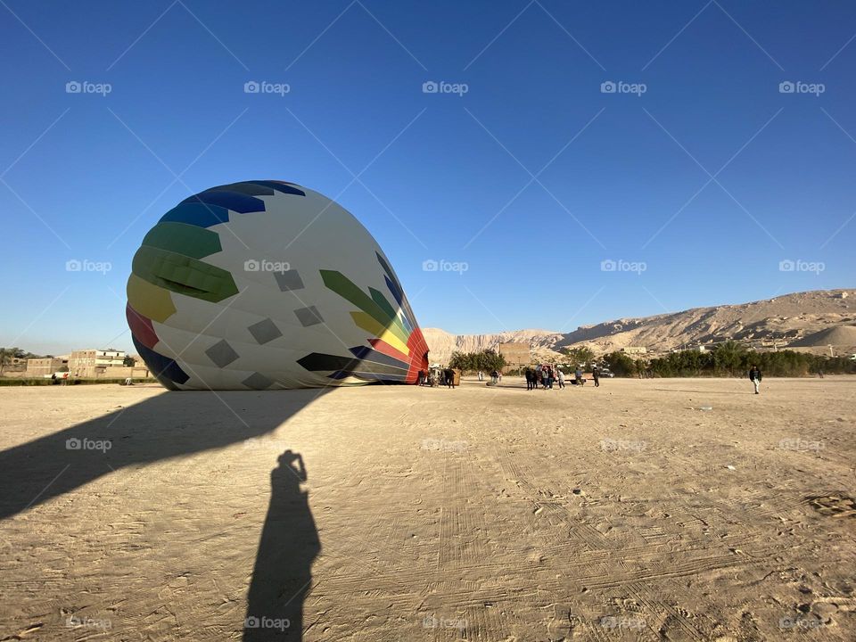 The shadow of a girl who is taking photo for the hot air balloon