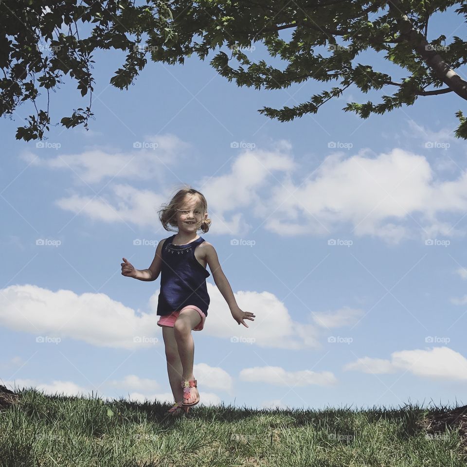 A little girl walking on grassy field