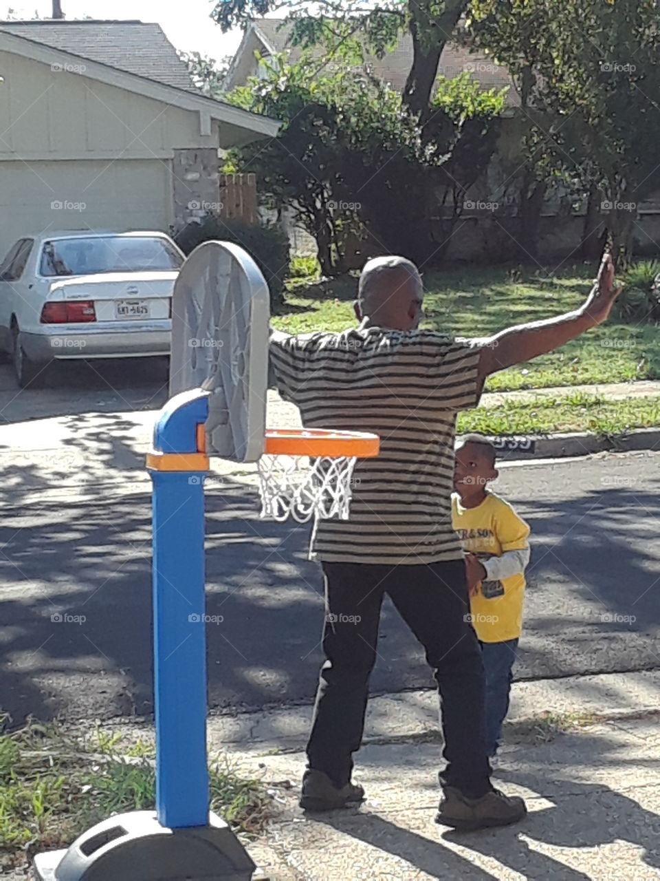grand uncle playing basketball with grand nephew