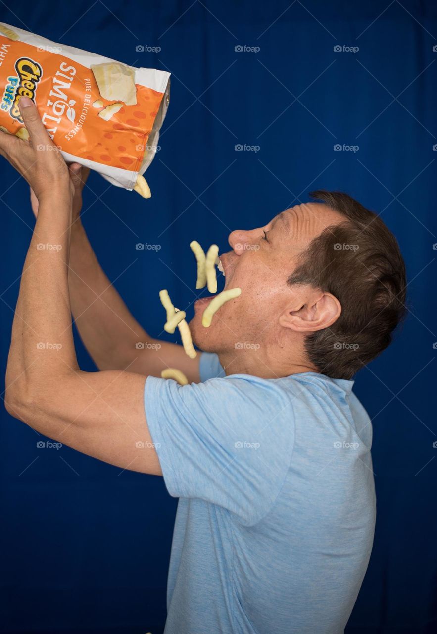 Man devouring Cheetos 