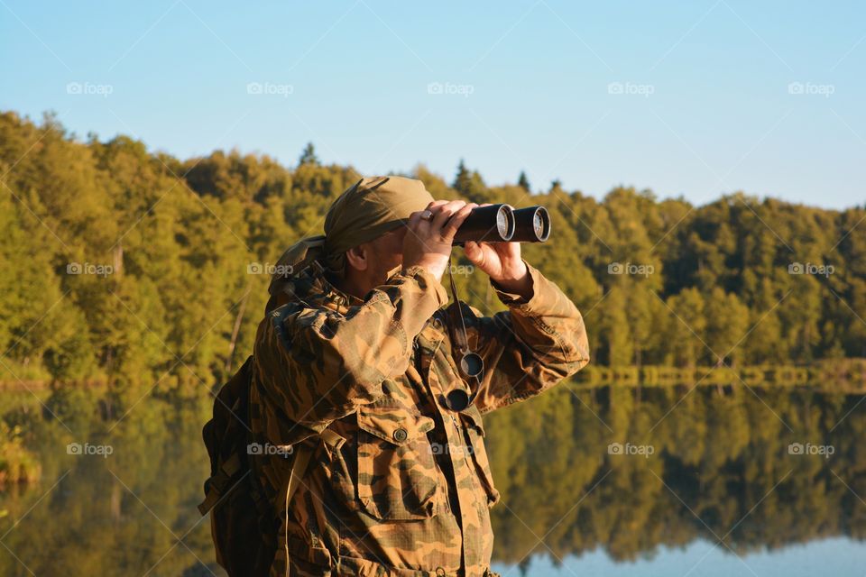 A man looks through binoculars