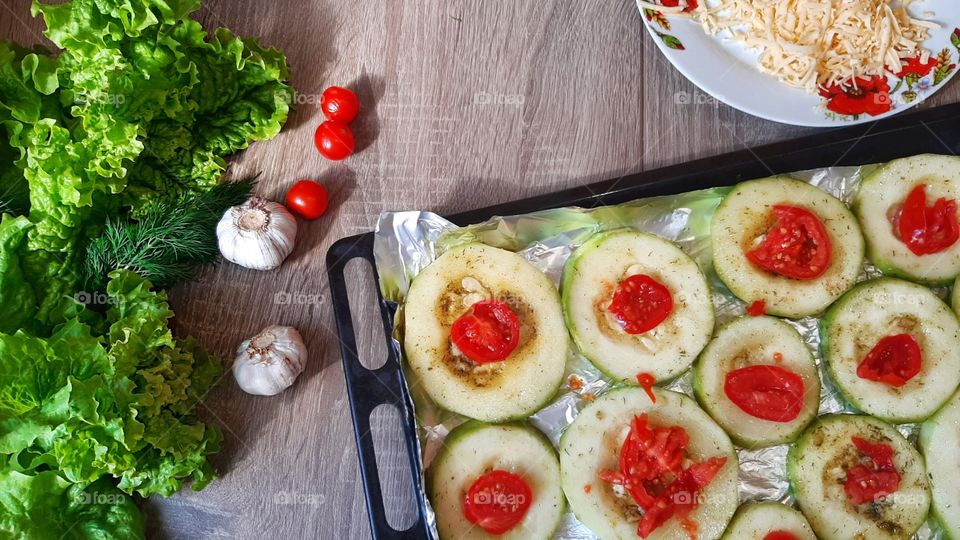 Zucchini under tomato in garlic during cooking