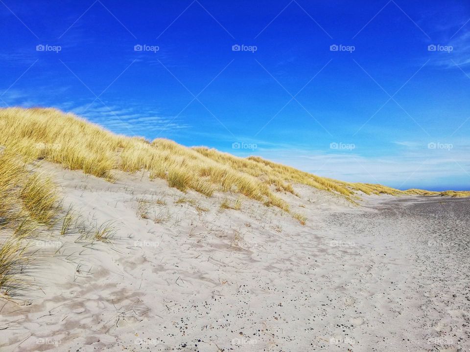 Hot sand in the dunes with blue sky.