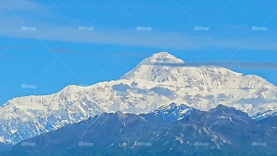 Majestic Mt Denali comes out of her clouds on a rare clear sky day. Alaska