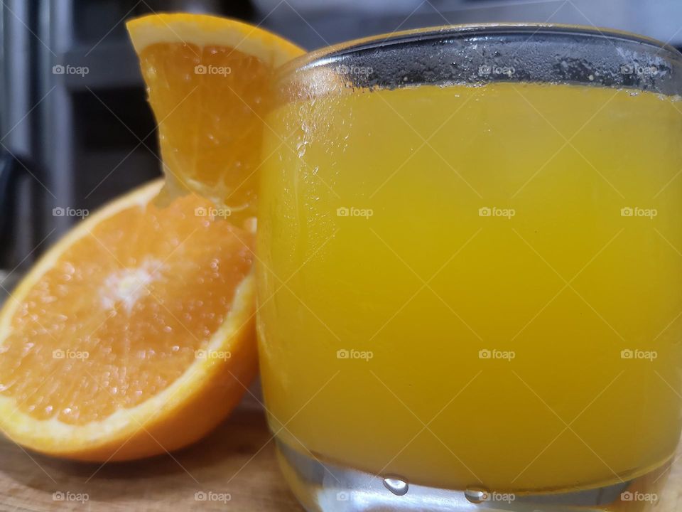 A glass of freshly squeezed orange juice with ice cubes