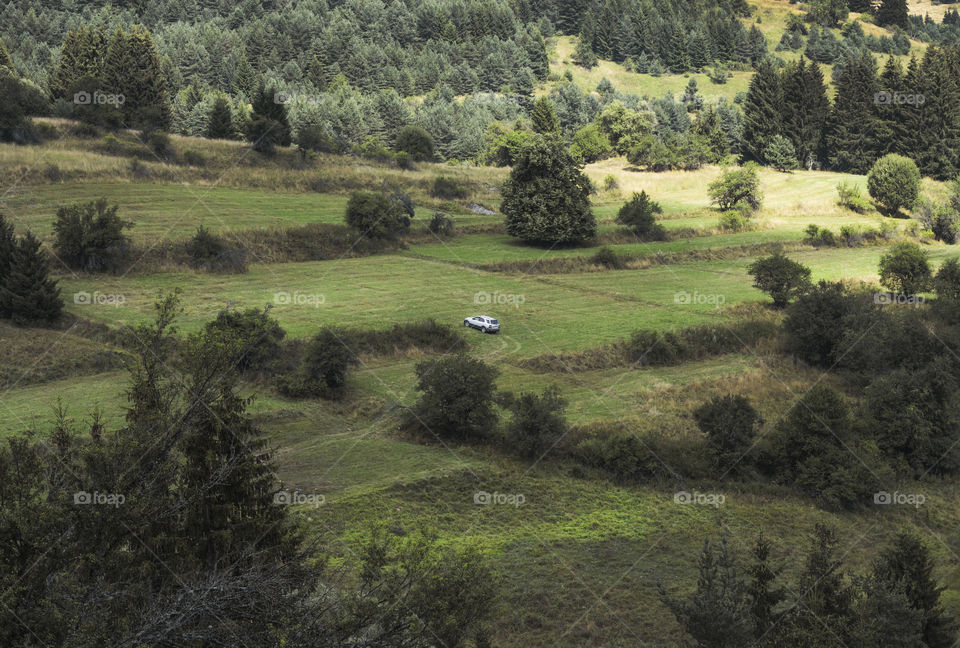 one car in the grassland field, mountain view, aerial, minimalism