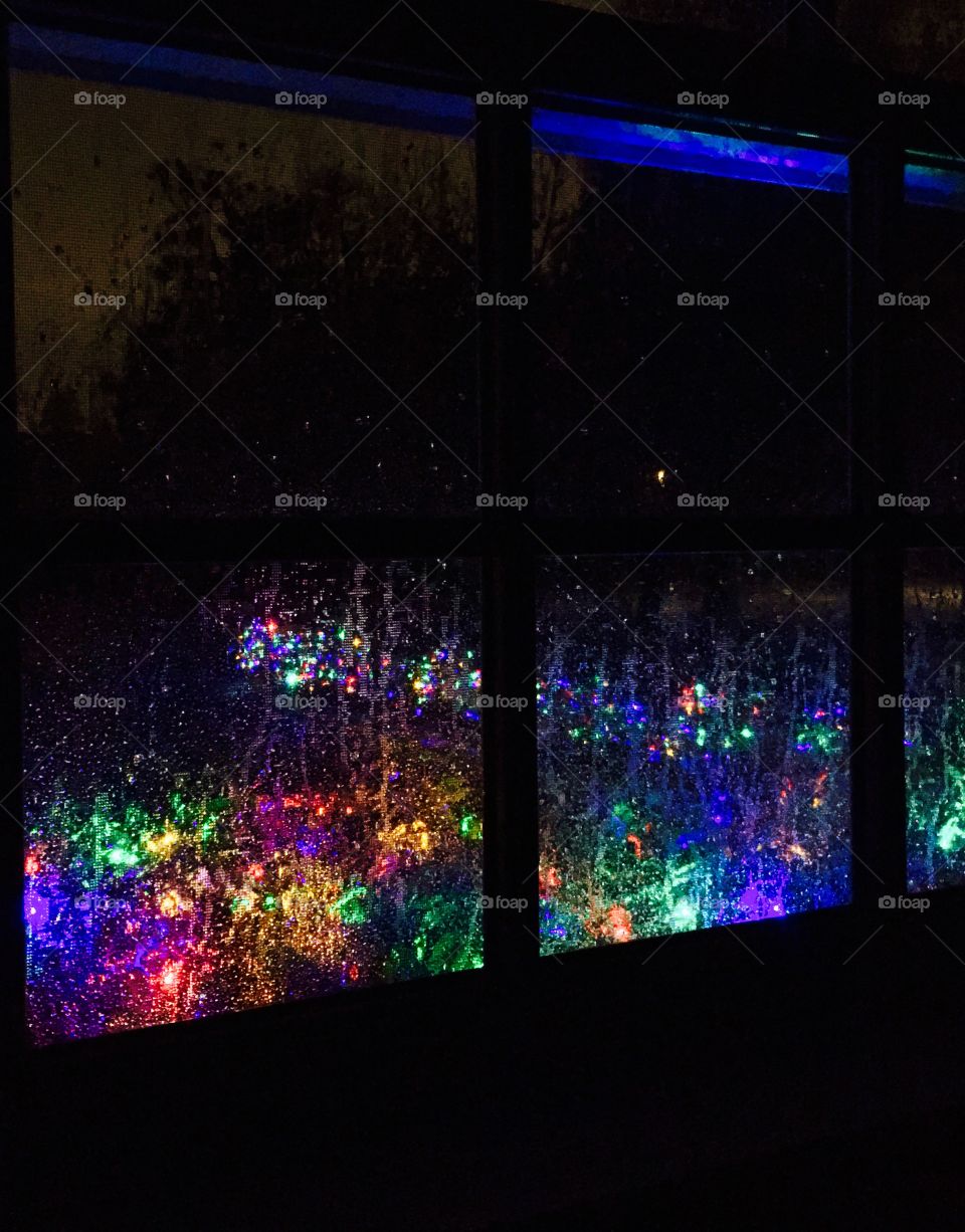 Christmas Lights through the window after a nighttime rain. 