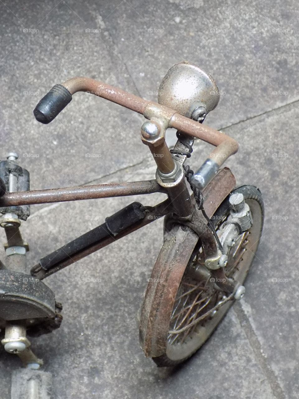 Old, rusty and broken toy bicycle