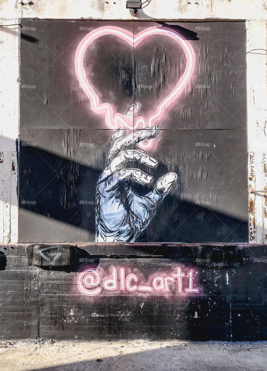 Street Art- hand and neon pink heart