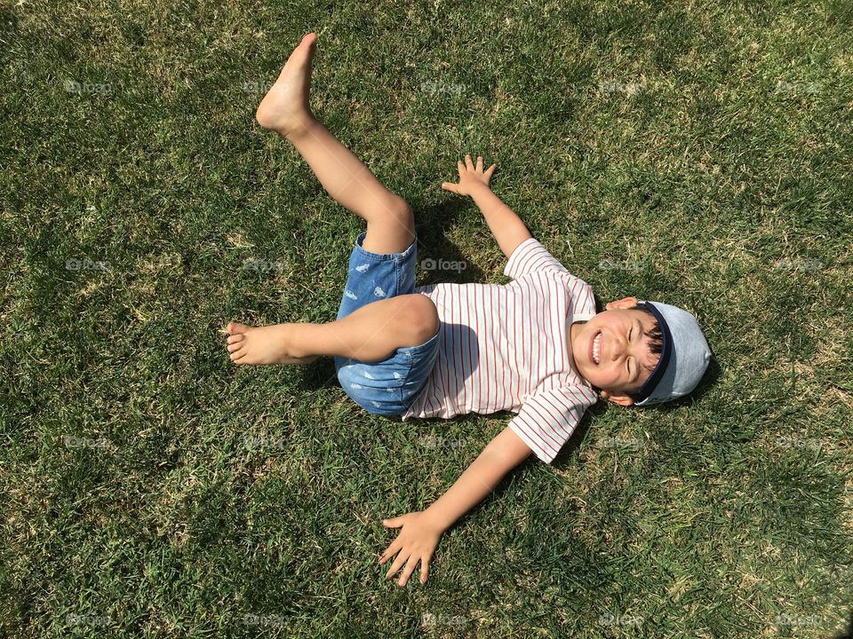 Cute boy playing on grassy land