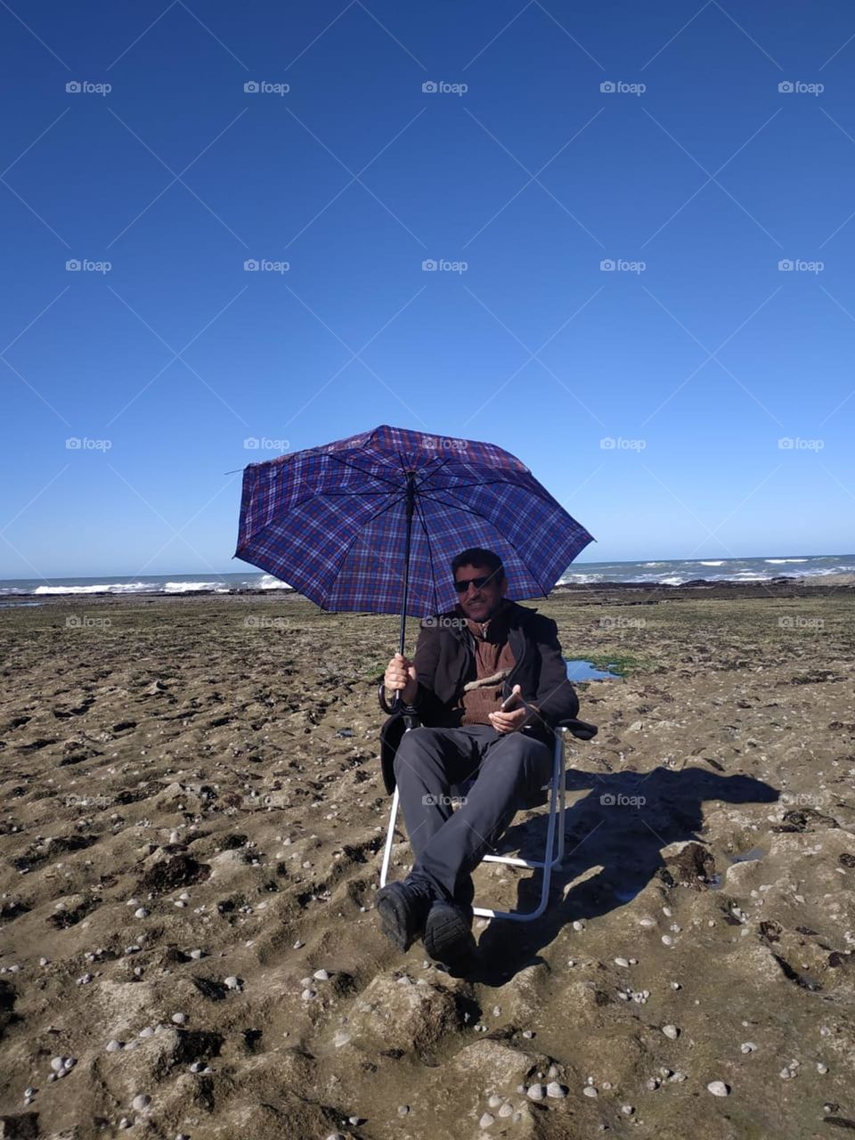 Im sitting near the sea hiding by my umbrella at essaouira city in Morocco.