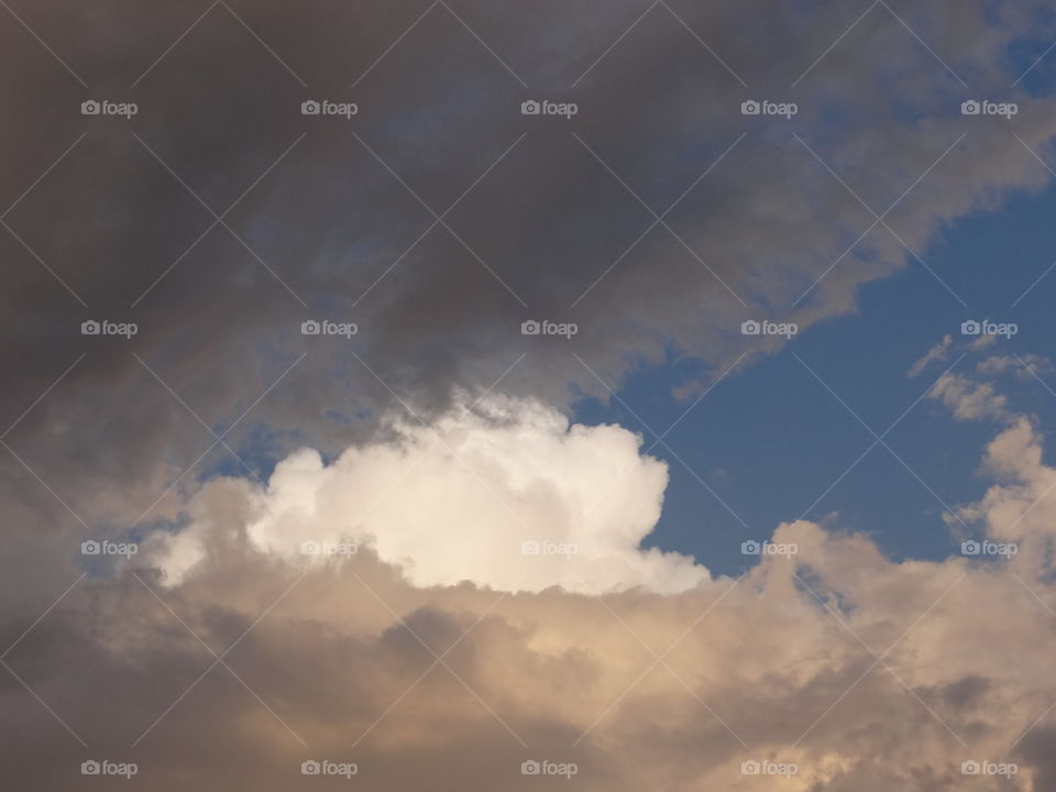 Hope Peeks Through the Storm. A bright white cloud peeks out between grey storm clouds