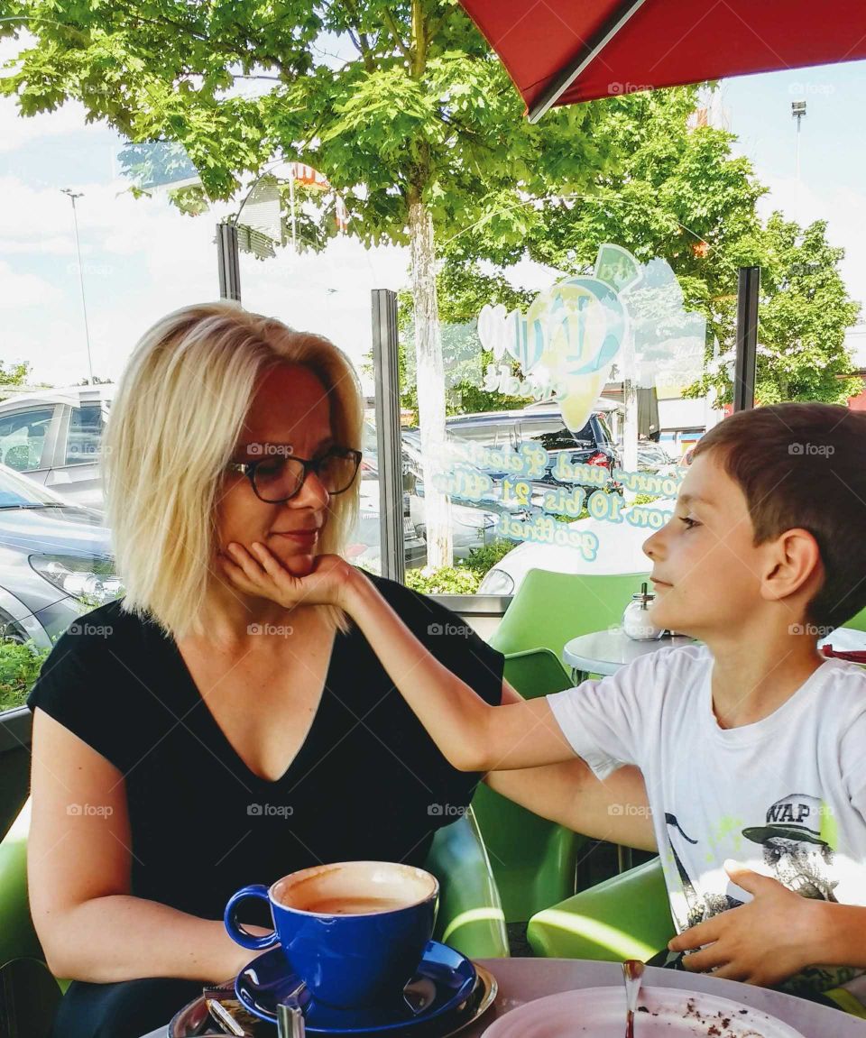 Blonde woman with her cute son sitting in cafe
