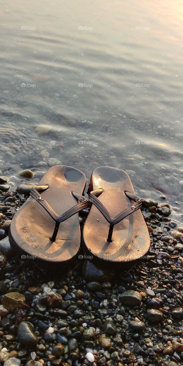 My flip flops on the rocky beach at sunset.
