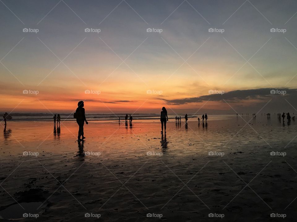 Majestic sunset in Bali, Indonesia, in Seninyak beach. The amazing sky colours makes this photo look like a painting! The reflection of the sun on the wet sand makes this photo a complete piece of art.