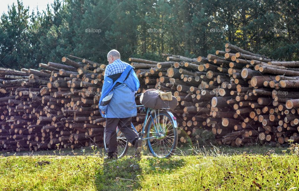 men with bike walking fallen trees background