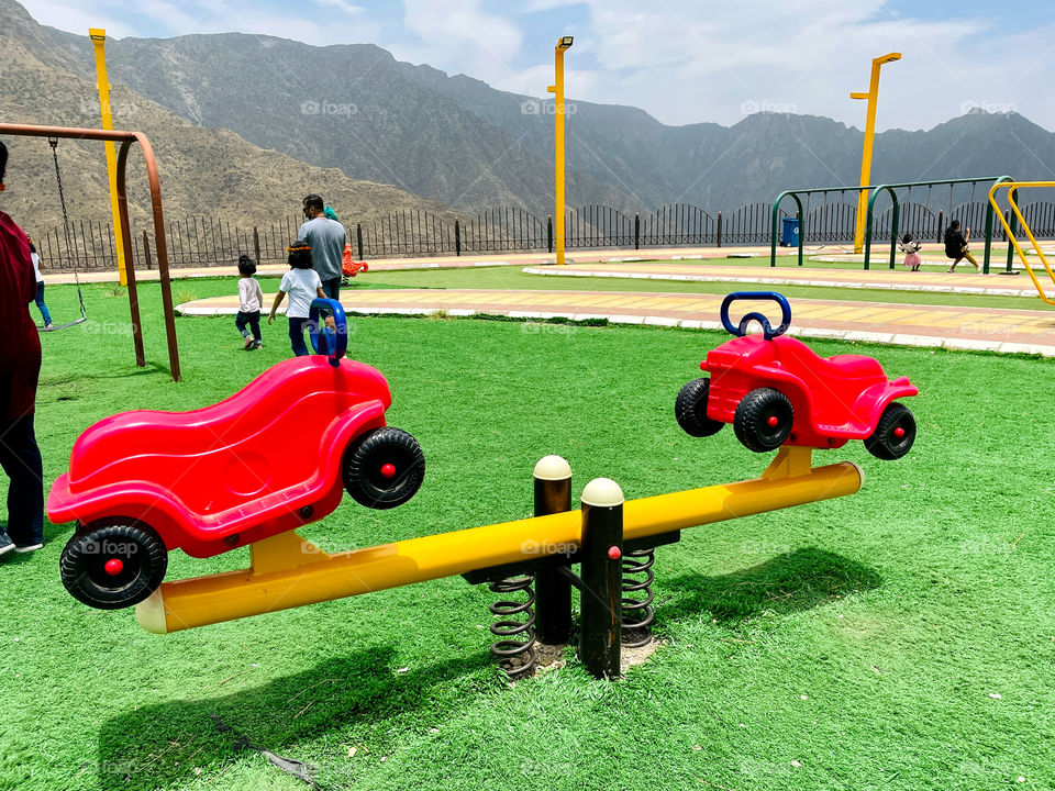 Red car model Seesaw in a  play ground . Colour Red