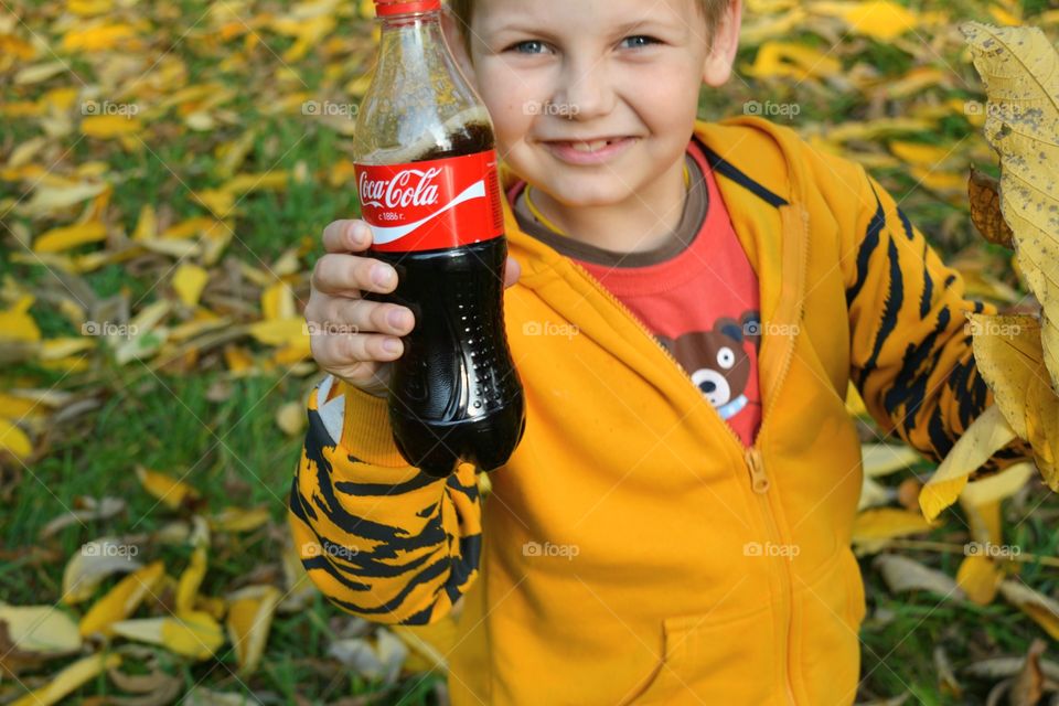 coca cola in the hand child drinking coca cola outdoor