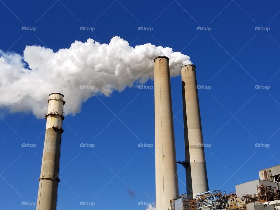 Billowing fluffy white power plant smoke stacks
