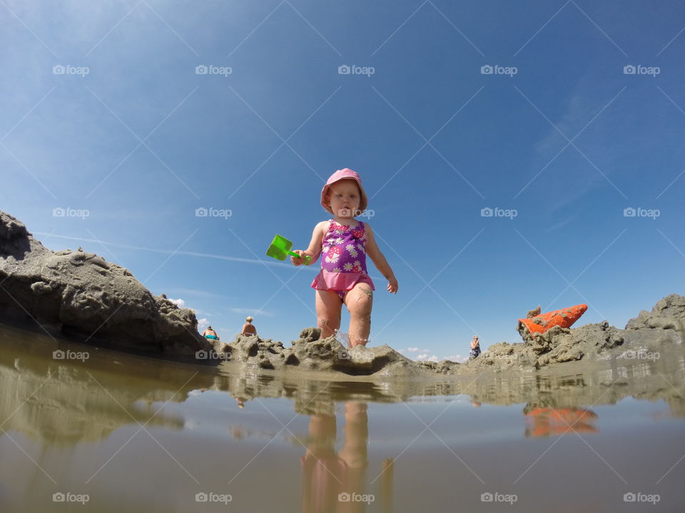One year old girl is playing on the beach in Lomma in Sweden.