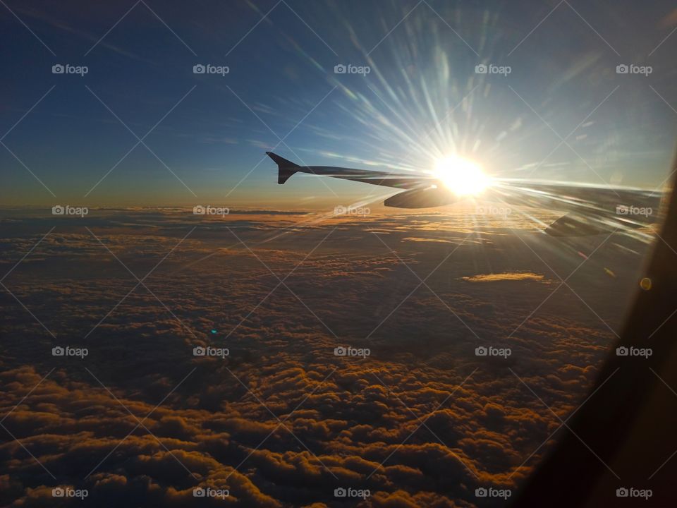 rising sun over airplane wing