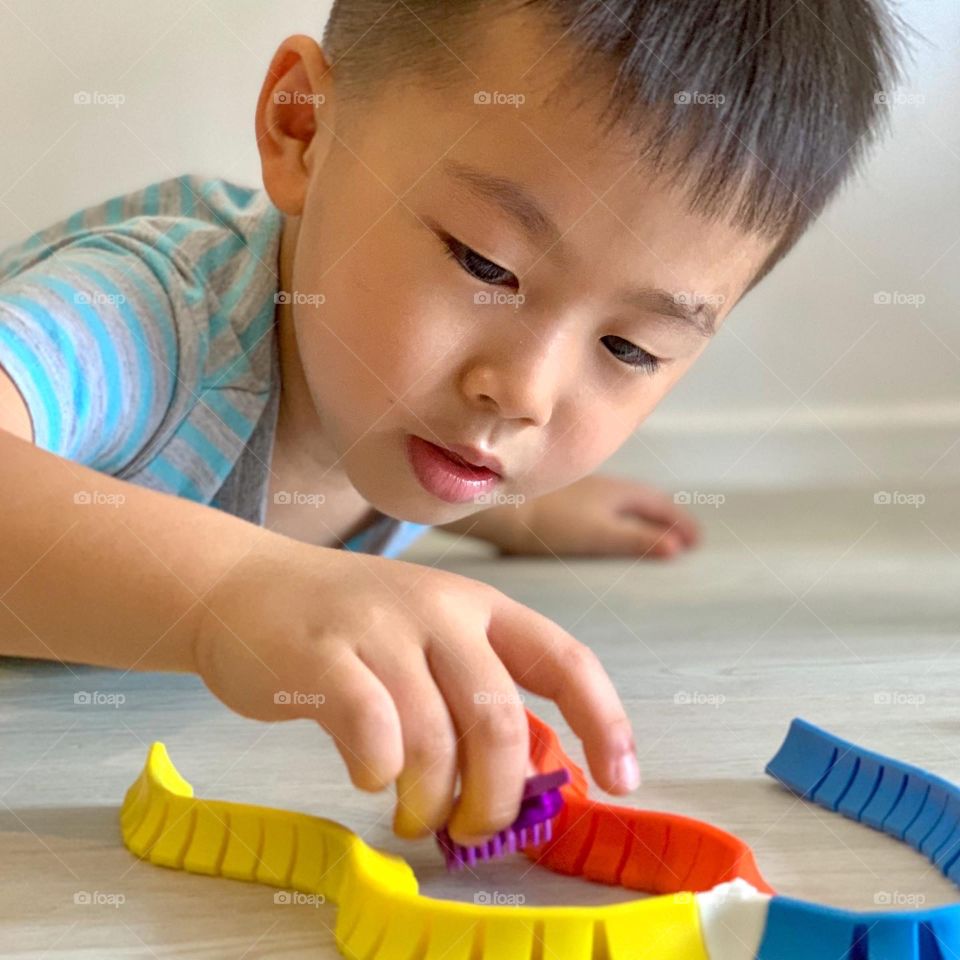 Asian boy playing with colourful toys 