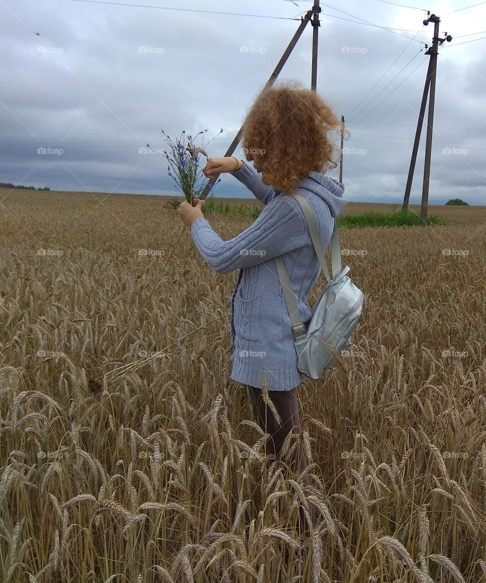 girl in grain field summer time
