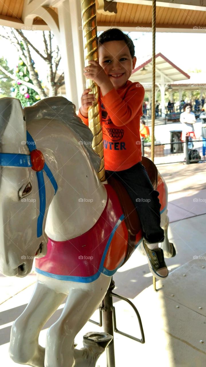 Dimpled boy on a merry-go-round.