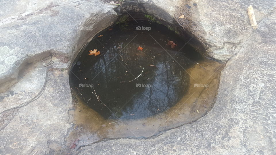 hole carved in granite rock by water and stones