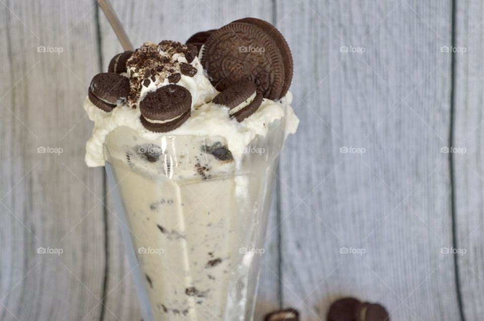 Oreo cookie milkshake with a wooden rustic white background