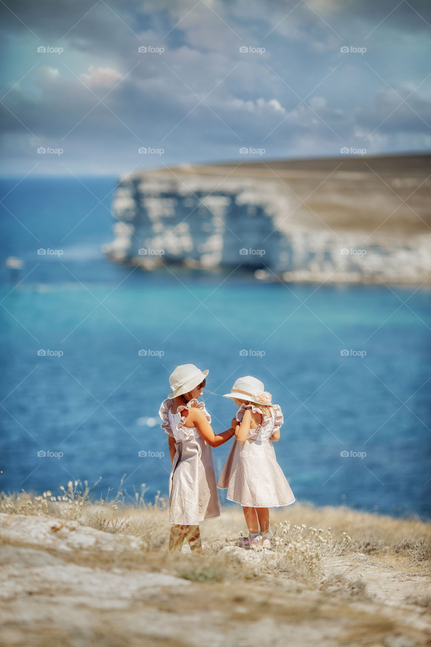 Little sisters on sea coast 