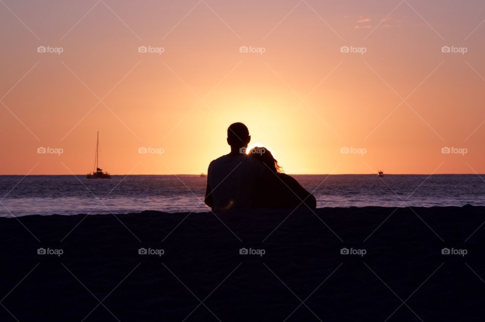Couple watching sunset at the beach