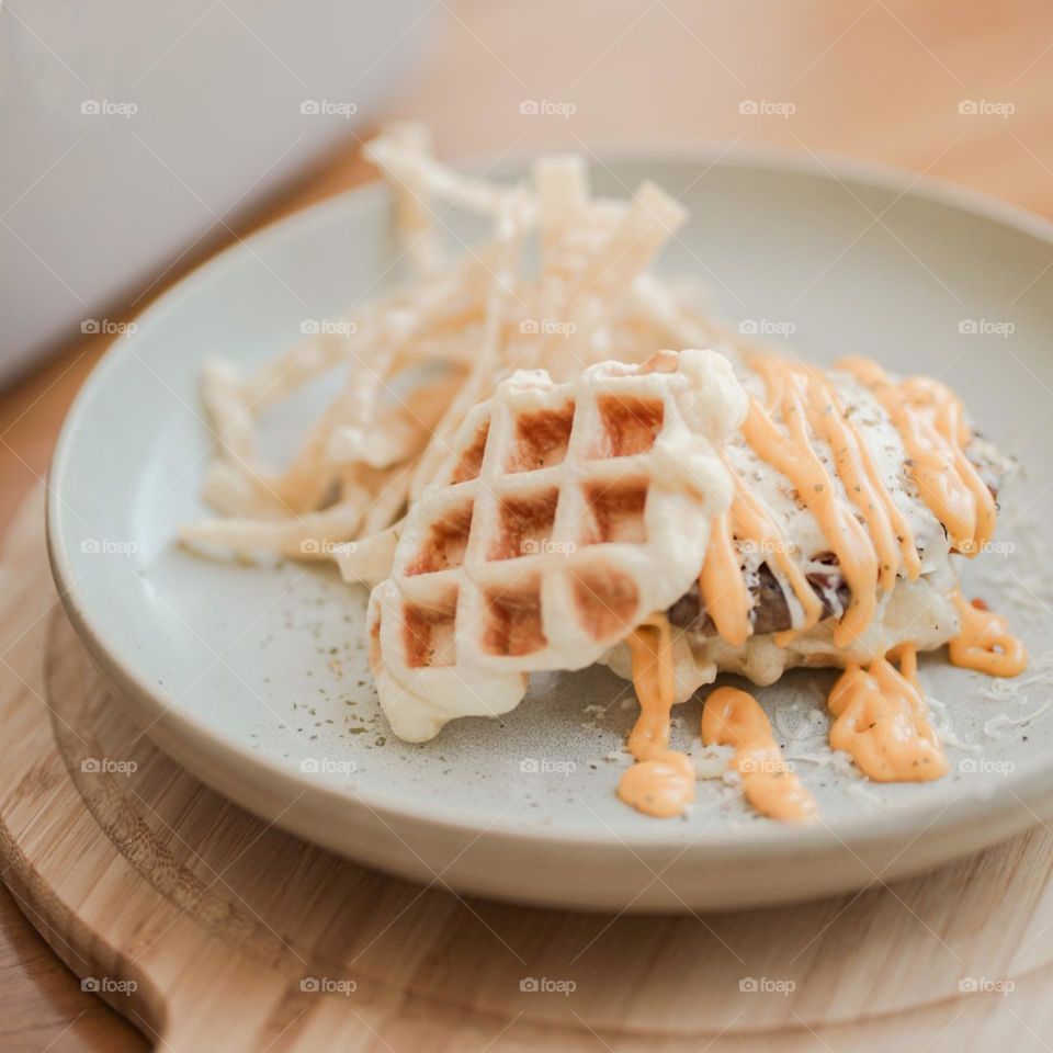 Close-up of food in plate on table. Food. Eat. Lunch. Breakfast. Snacks. Dessert. Photography. Aesthetic. Isolated background. Pastel colors. Waffles. Mayonnaise. Cream. Plate. Cafe. Table. Wood motif