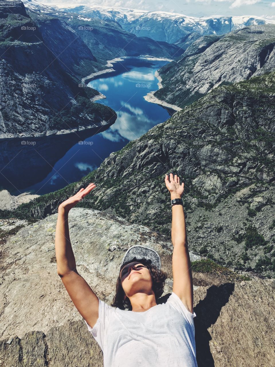 Happy girl on the edge of Prekestolen rock in Norway. 